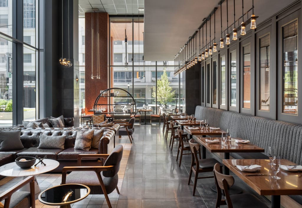 Modern restaurant interior with leather booths, wooden tables, and large windows in Atlanta, Georgia.
