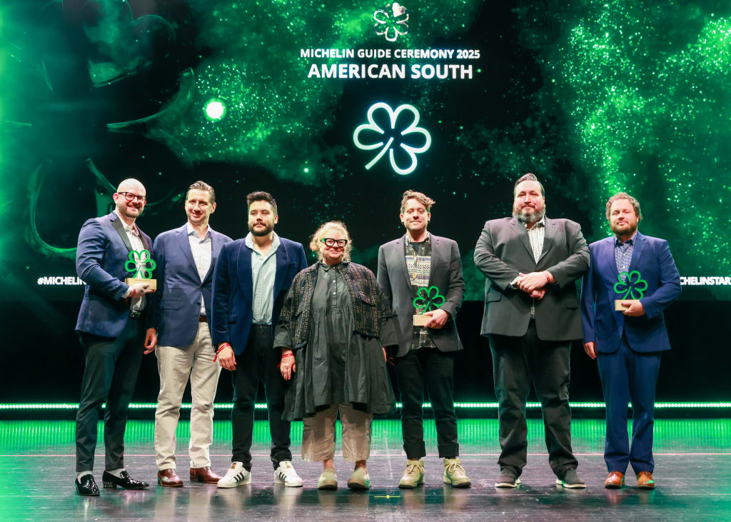 Group of eight people on stage holding awards at Michelin Guide Ceremony 2025 in Atlanta, Georgia.