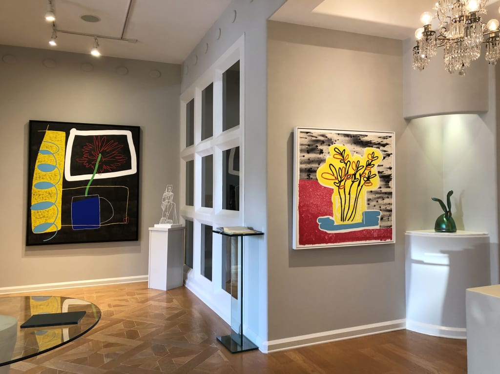 A modern art gallery with abstract paintings, sculptures, and a chandelier in Atlanta, Georgia.