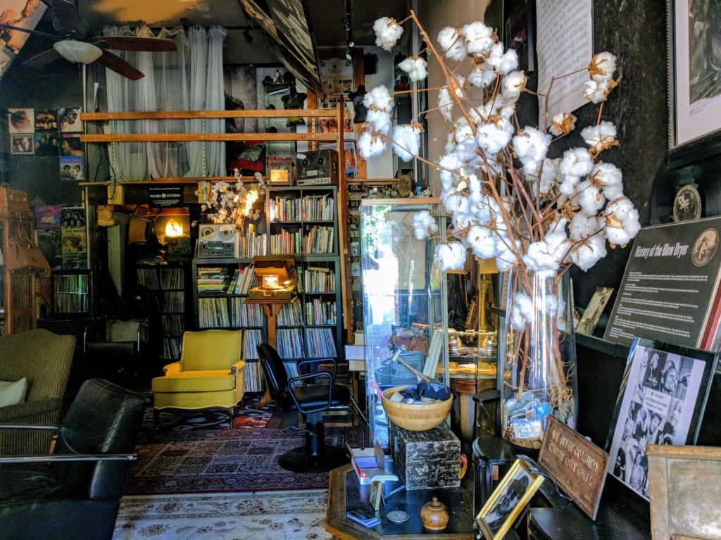 A cozy, cluttered bookstore with vintage furniture, books, and cotton decorations in Atlanta, Georgia.