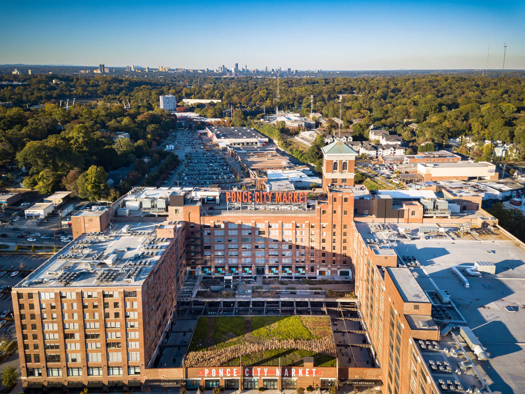 Aerial view of a large brick building complex with a green roof and a clock tower in Atlanta, Georgia.