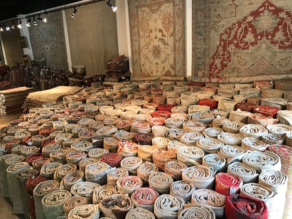 A large warehouse filled with rolls of colorful rugs and carpets in Atlanta, Georgia.