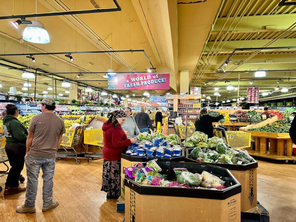A bustling grocery store with a wide variety of fresh produce and shoppers in Atlanta, Georgia.