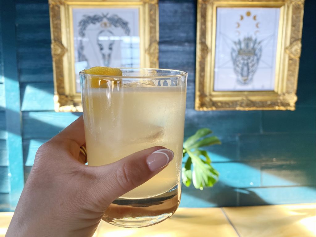 Must-Try Summer Cocktails in Atlanta 5 Hand holding yellow drink.