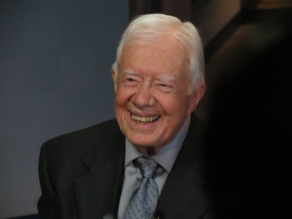 An elderly man with white hair is smiling broadly while wearing a suit and tie in Atlanta, Georgia.