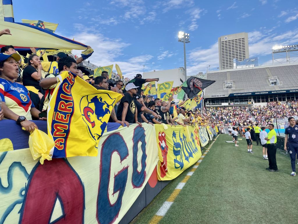 A vibrant soccer stadium filled with enthusiastic fans waving colorful flags and banners in Atlanta, Georgia.