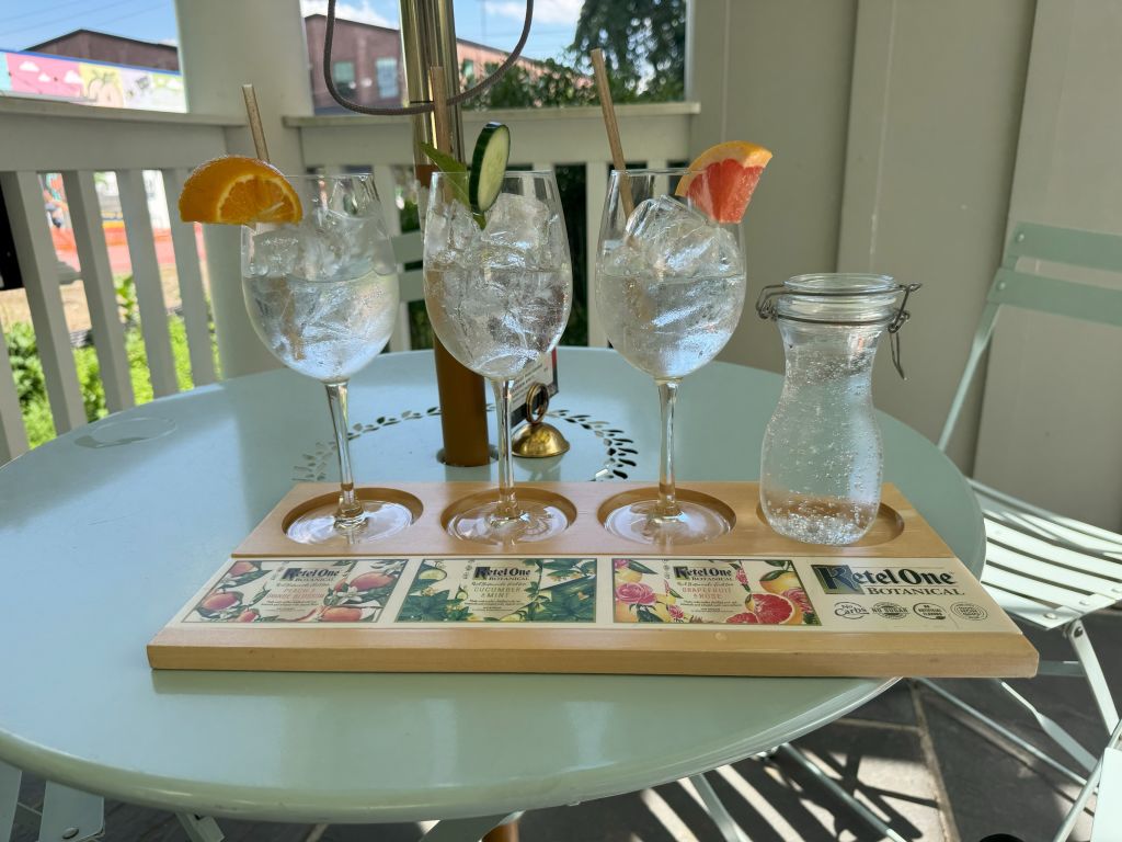 Three glasses of sparkling water with citrus garnishes on a wooden tray in Atlanta, Georgia.