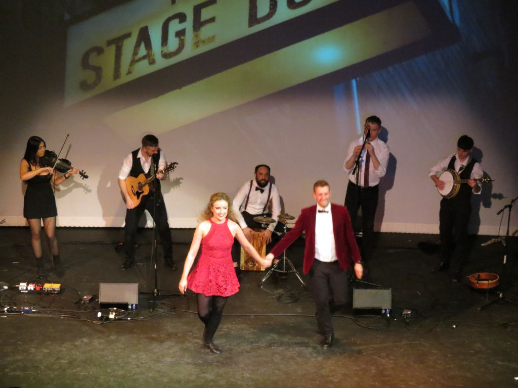 A lively stage performance featuring a couple dancing, accompanied by a band playing various instruments in Atlanta, Georgia.