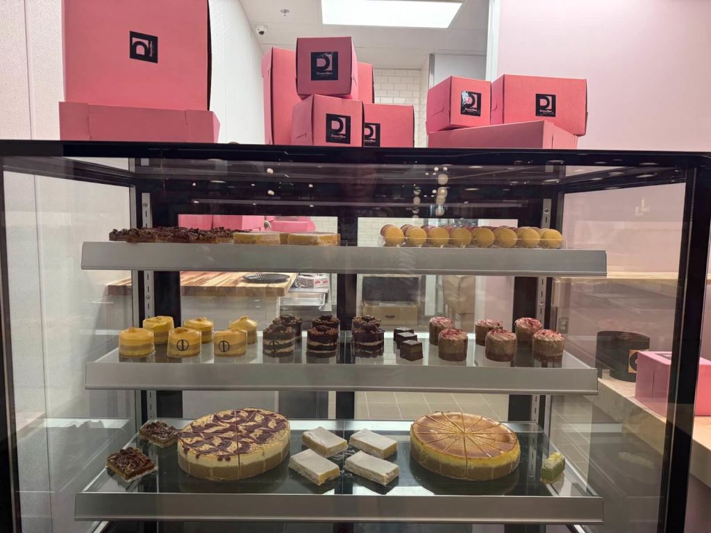 A variety of colorful desserts and pastries displayed in a glass case at a bakery in Atlanta, Georgia.