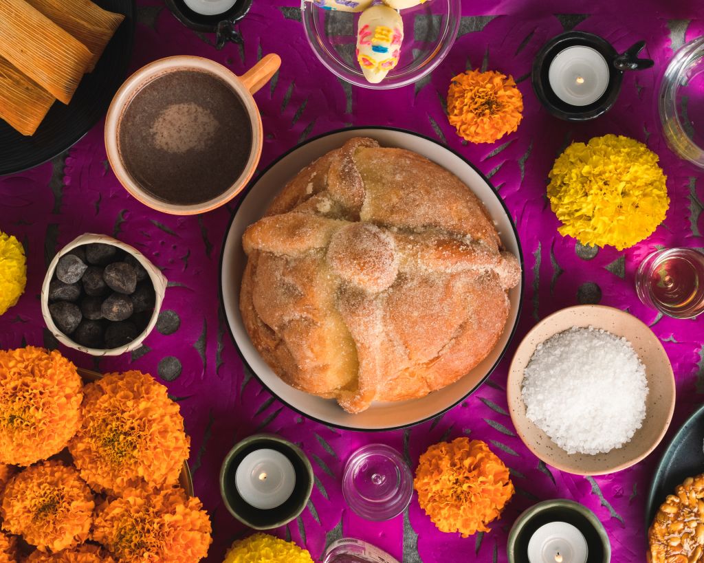 A vibrant table setting with marigold flowers, sugar skulls, and traditional Mexican foods in Atlanta, Georgia.
