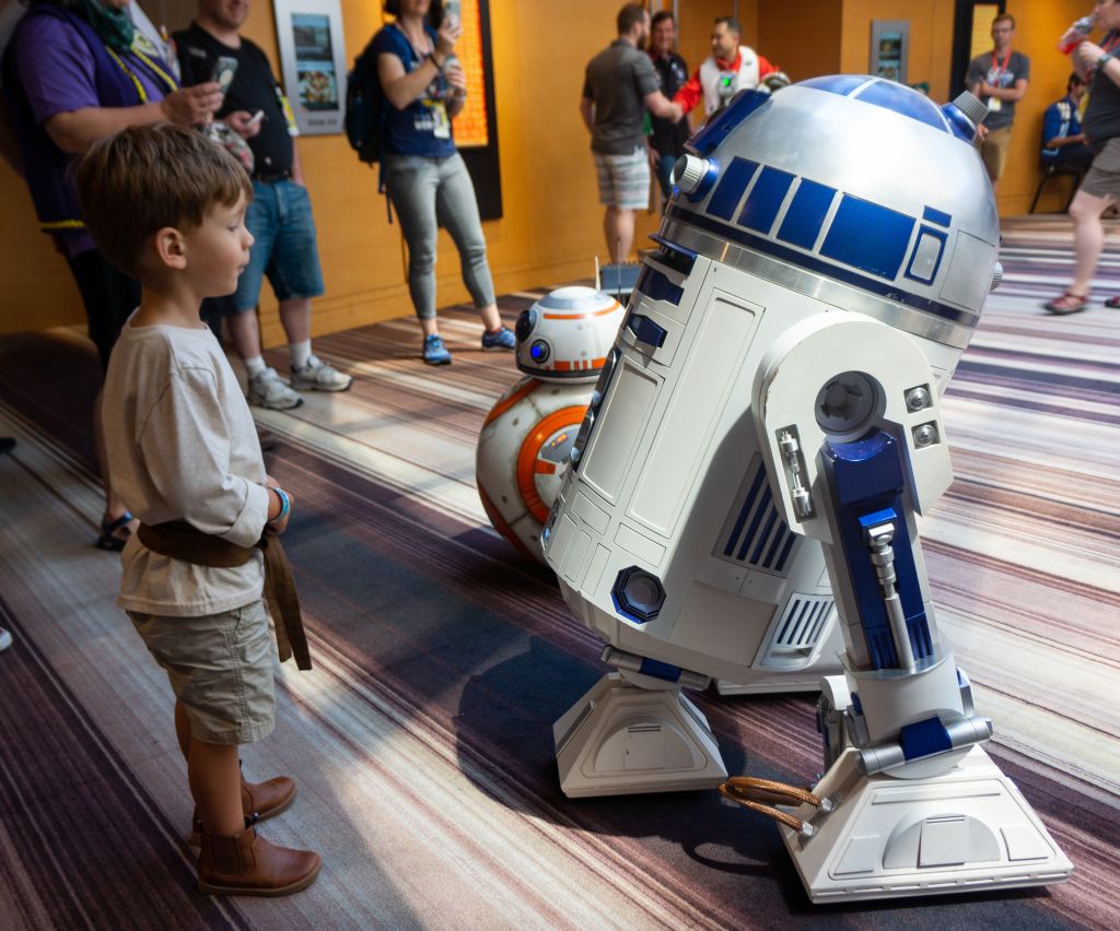 A young boy stands in awe of a life-sized R2-D2 robot at a convention in Atlanta, Georgia.