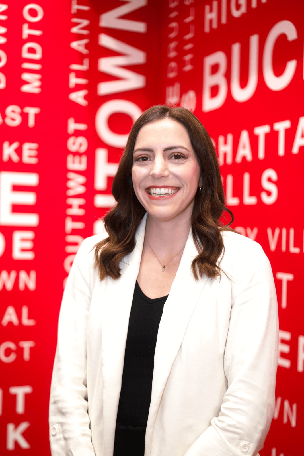 Explore Atlanta Beltline Southeast Trail 8 A smiling woman in a white blazer stands against a red background with city names in Atlanta, Georgia.