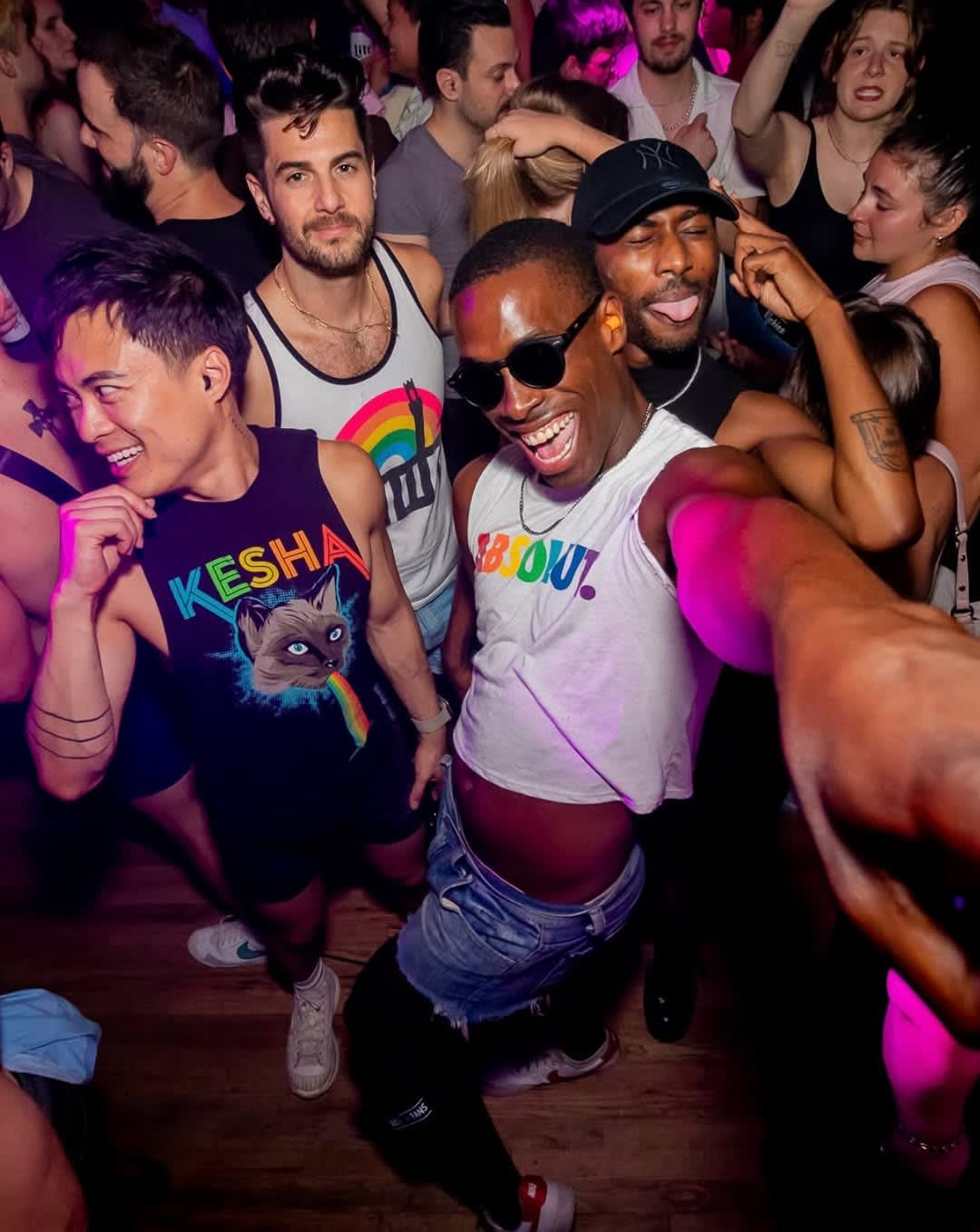A diverse group of people dancing energetically in a crowded, dimly lit nightclub in Atlanta, Georgia.