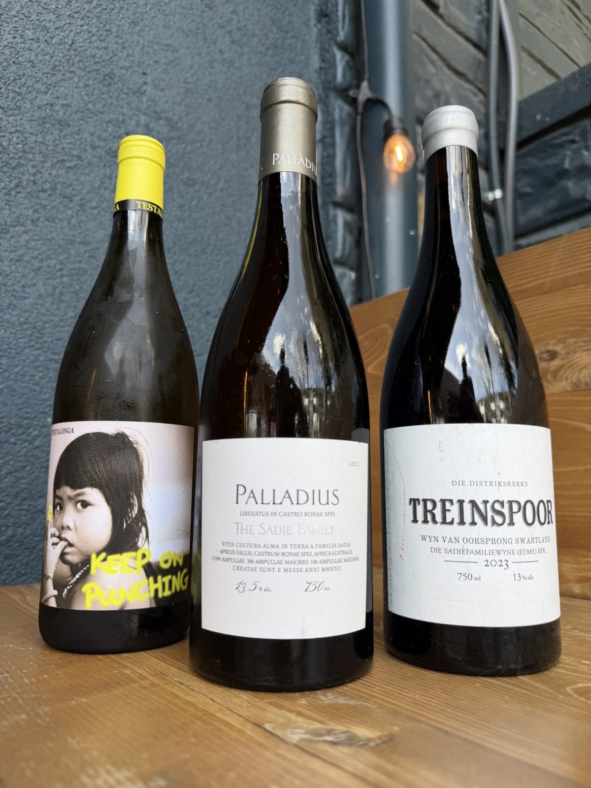 Ultimate Guide to South African Food and Wine in Atlanta 2 Three bottles of wine with distinctive labels, including one with a black and white photo of a child and the text 'Keep on Punching' in Atlanta, Georgia.