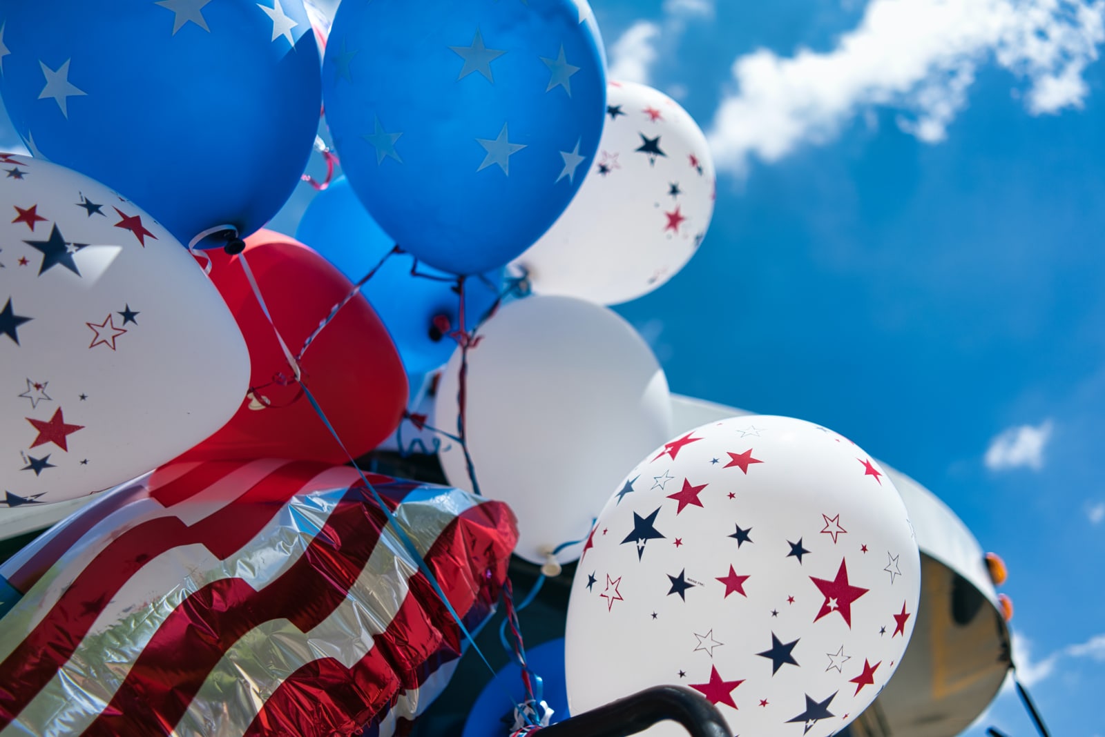 Independence Day Fireworks Light Metro Atlanta Skies 7 A cluster of patriotic balloons in red, white, and blue with star patterns float against a clear blue sky in Atlanta, Georgia.