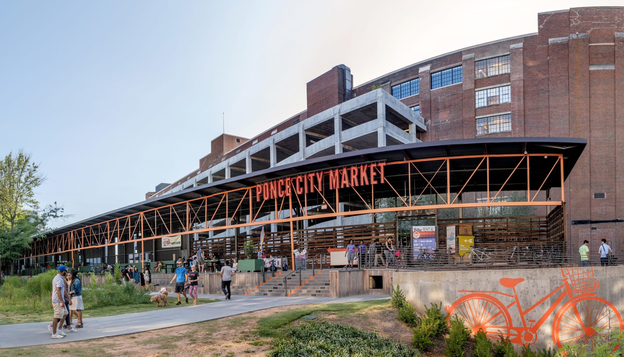 A bustling outdoor market with a modern, orange-accented structure and people shopping in Atlanta, Georgia.
