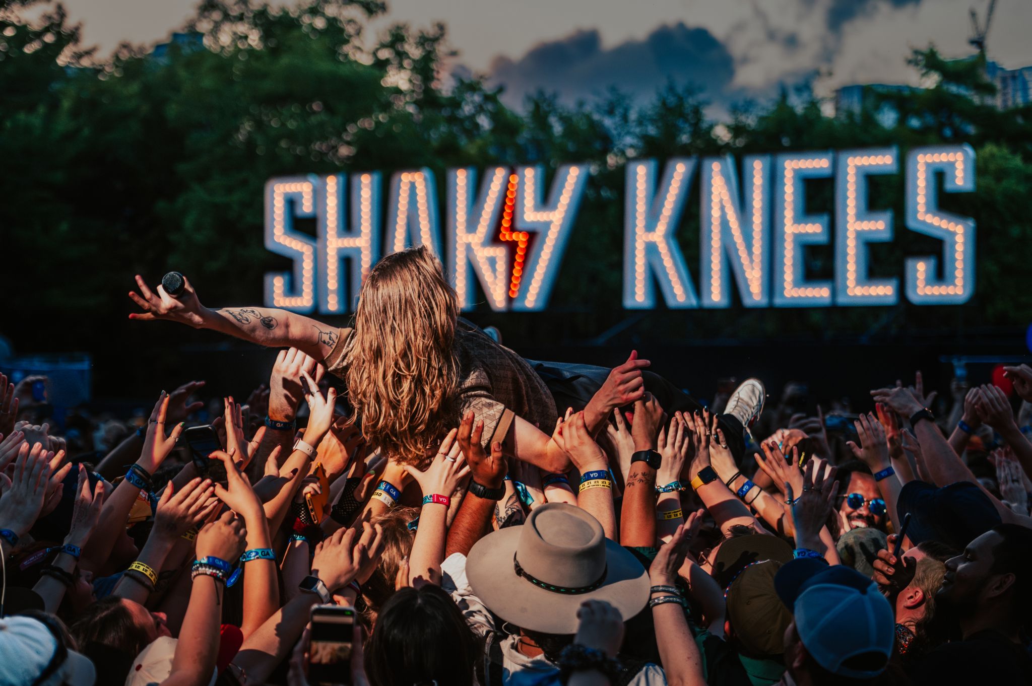 A crowd of people at a concert, reaching up to a performer on stage in Atlanta, Georgia.