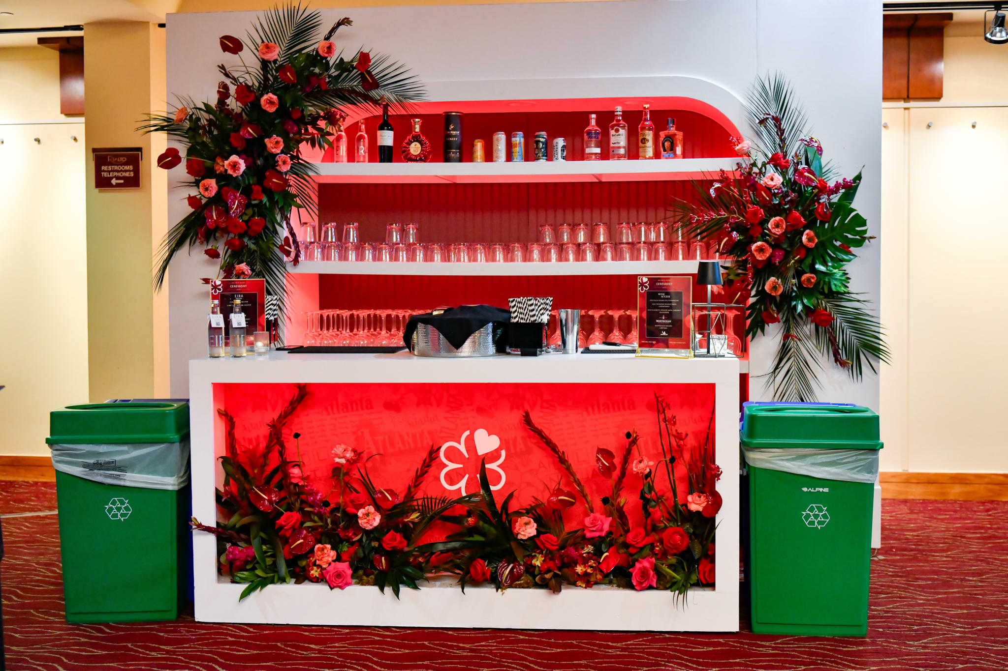 A vibrant floral-themed bar with red and green accents, featuring a variety of alcoholic beverages in Atlanta, Georgia.