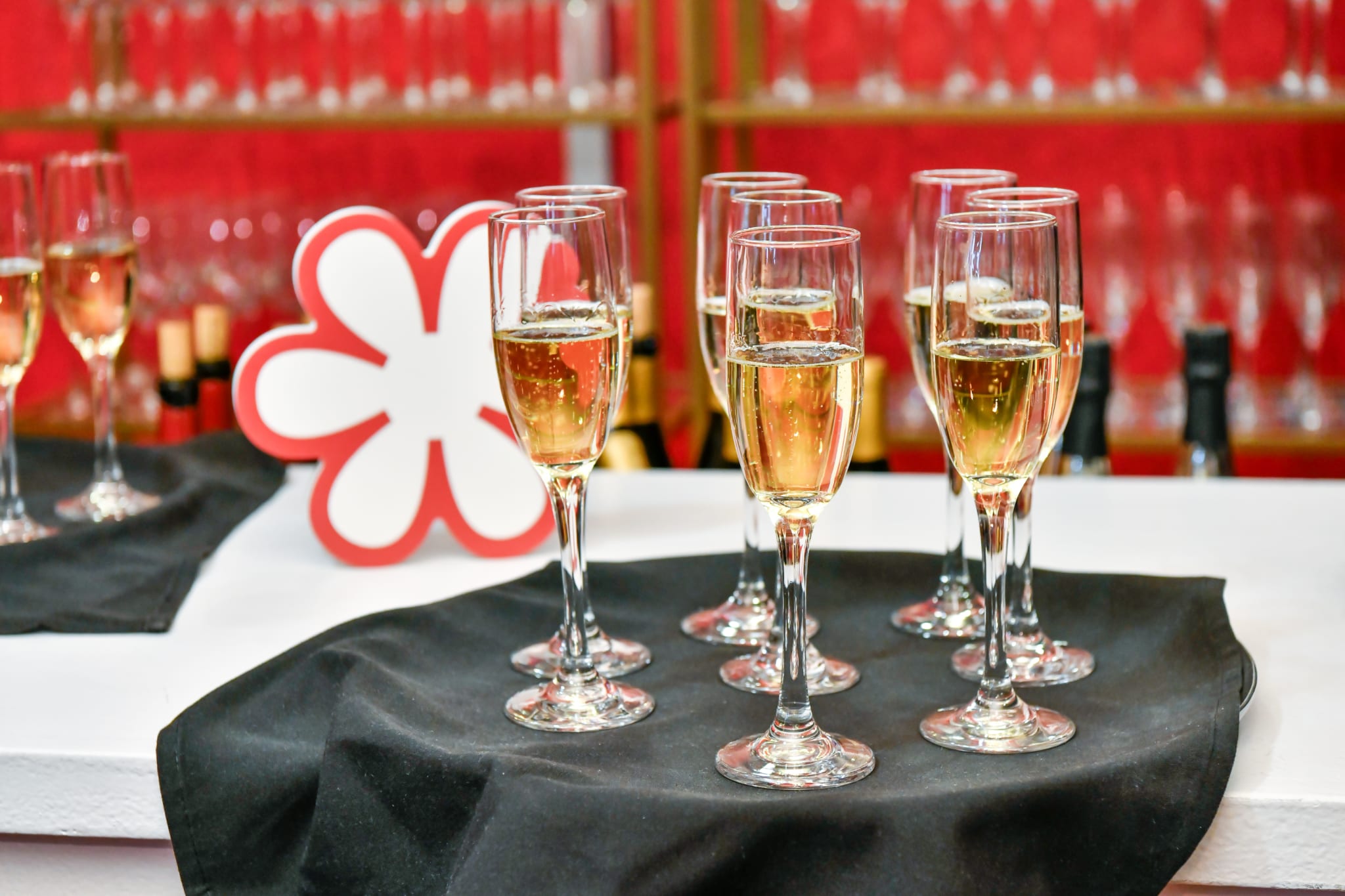 A tray of champagne flutes filled with sparkling wine on a black cloth in Atlanta, Georgia.