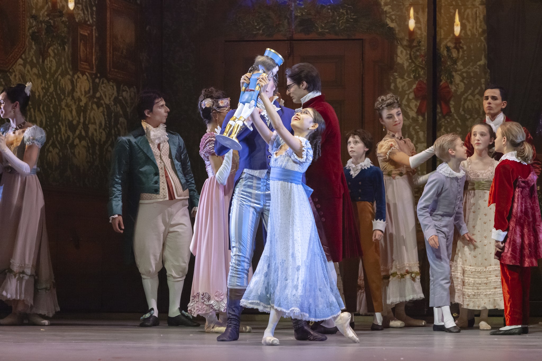 Ballet dancers in period costumes perform on stage with a large nutcracker figure in Atlanta, Georgia.