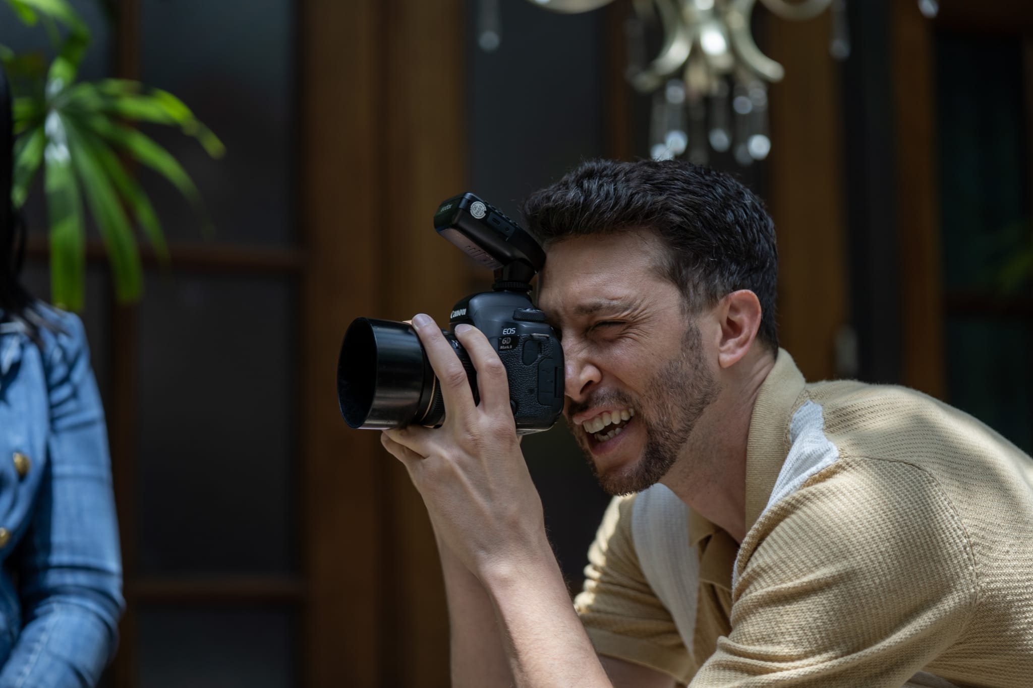 A man with a camera captures a moment, smiling broadly as he photographs a subject in Atlanta, Georgia.