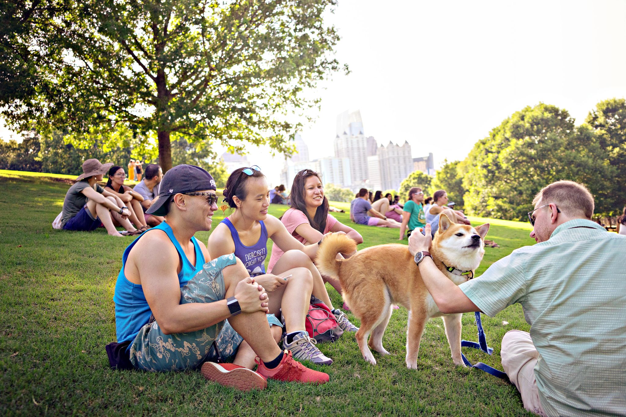 Couples enjoying each others company and their dog at Piedmont Park in Atlanta.
