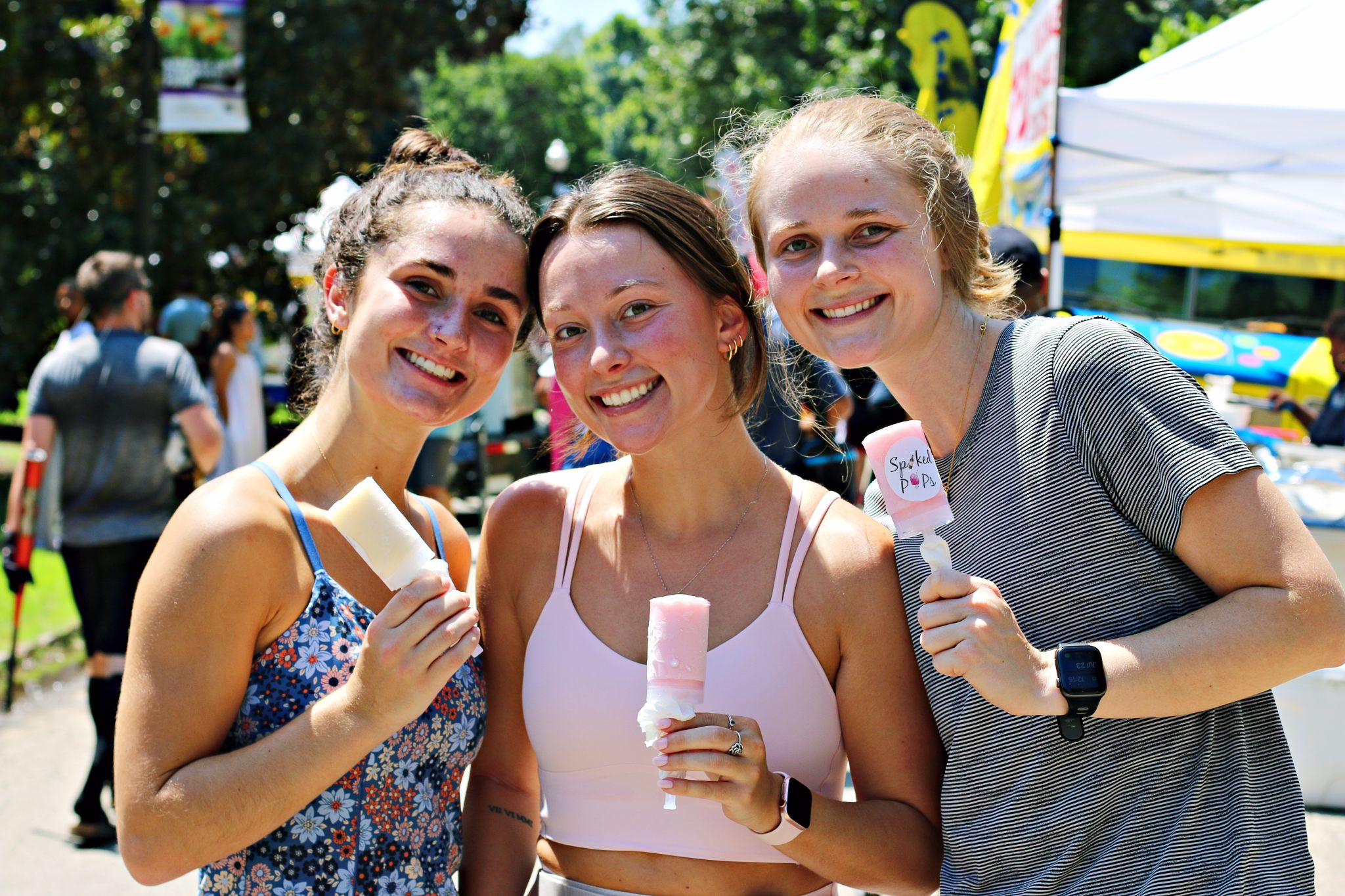 Guía para el mejor verano en Atlanta 1 Three women enjoying popsicles at an outdoor event, smiling at the camera in Atlanta, Georgia.