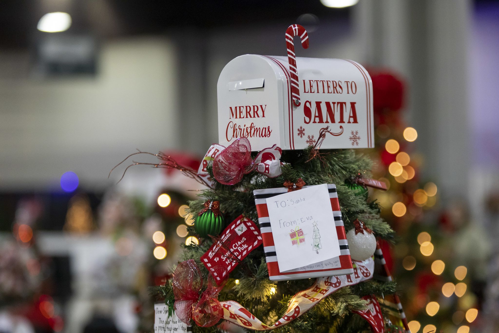 A decorated Christmas tree with a mailbox on top that says Letters to Santa from the Georgia Festival of Trees.