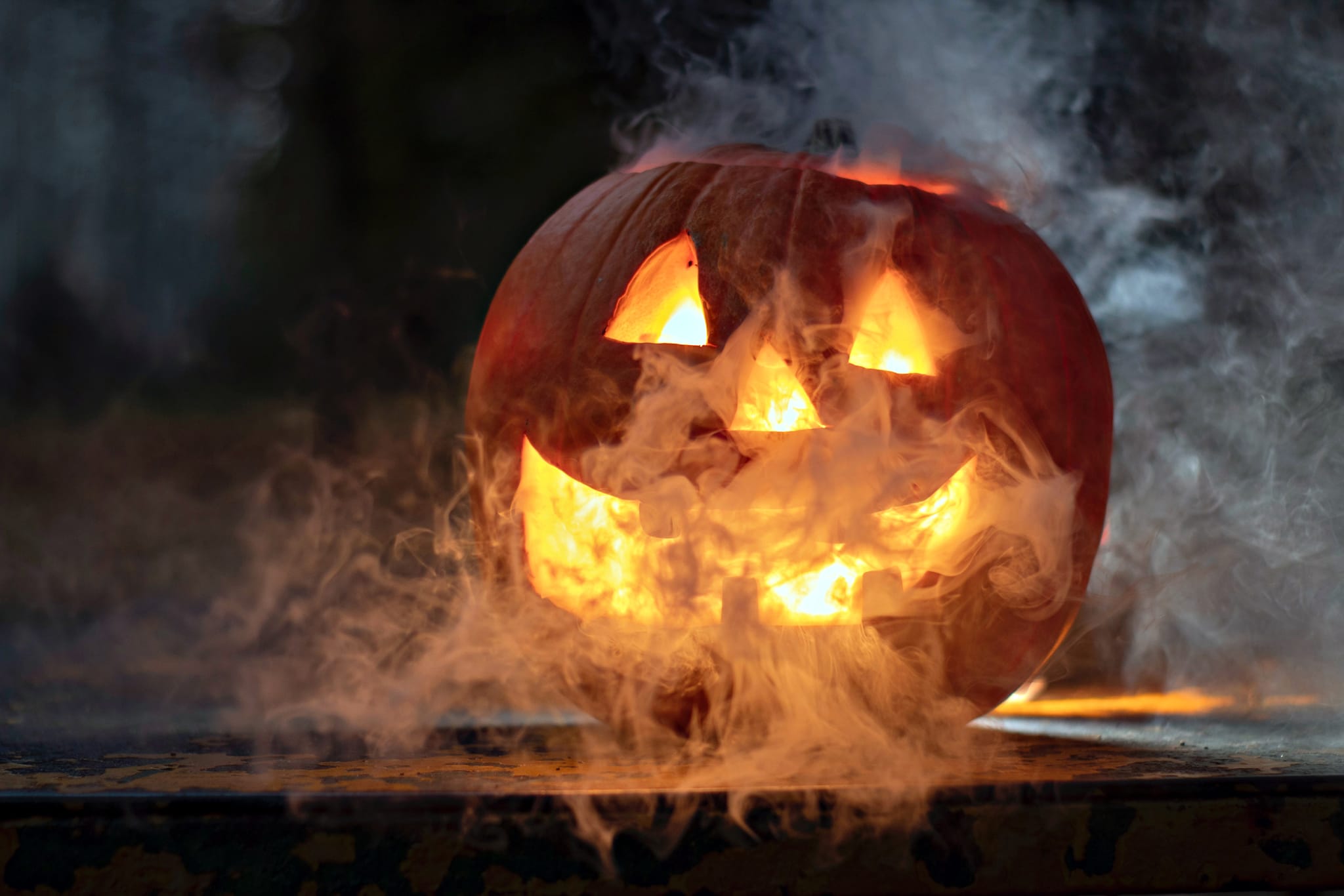A carved pumpkin with a smiling face emits smoke and flames from its mouth in Atlanta, Georgia.