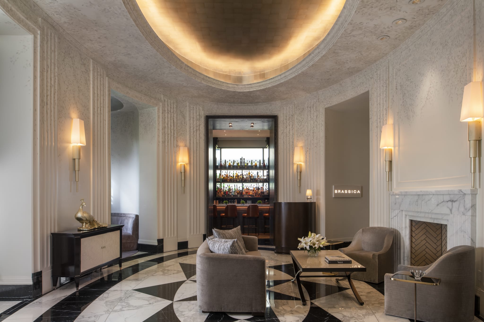 Elegant hotel lobby with marble floors, curved ceiling, fireplace, and bar area in Atlanta, Georgia.