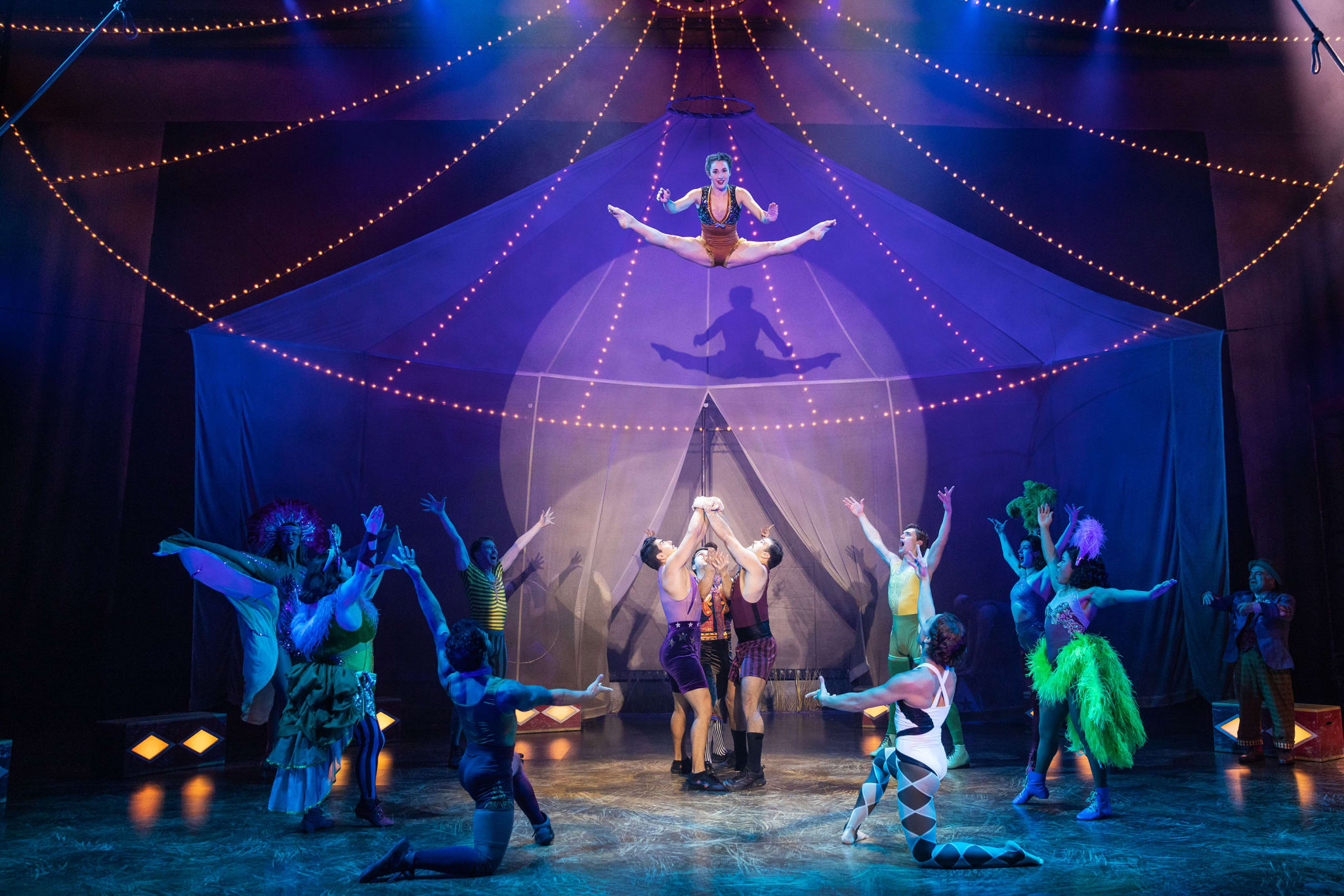 A vibrant circus performance featuring acrobats, clowns, and aerialists under a colorful big top tent in Atlanta, Georgia.
