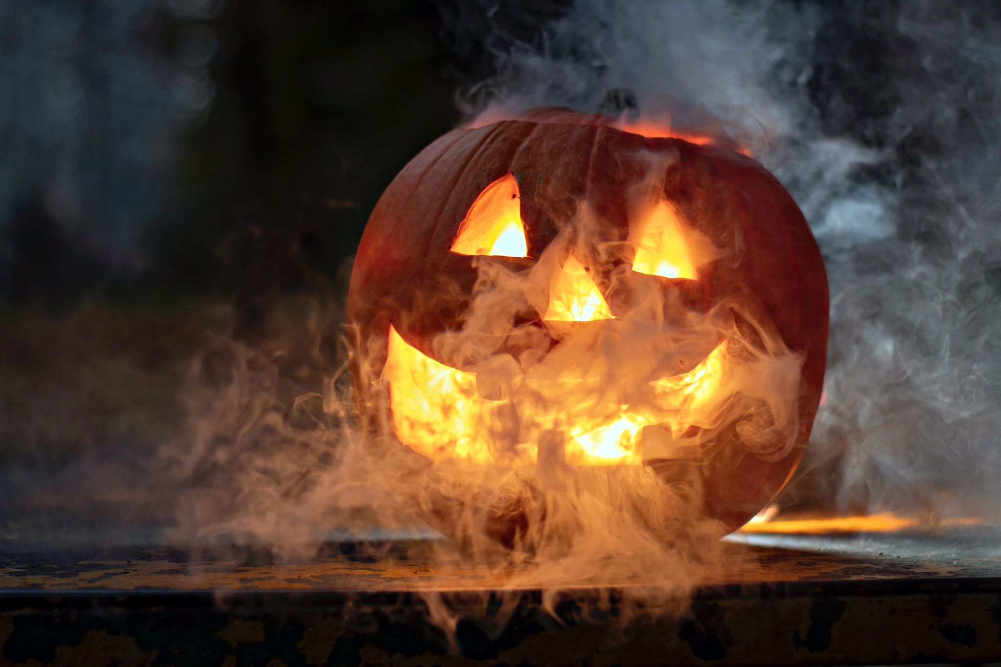 A carved pumpkin with a smiling face emits smoke and flames from its mouth in Atlanta, Georgia.