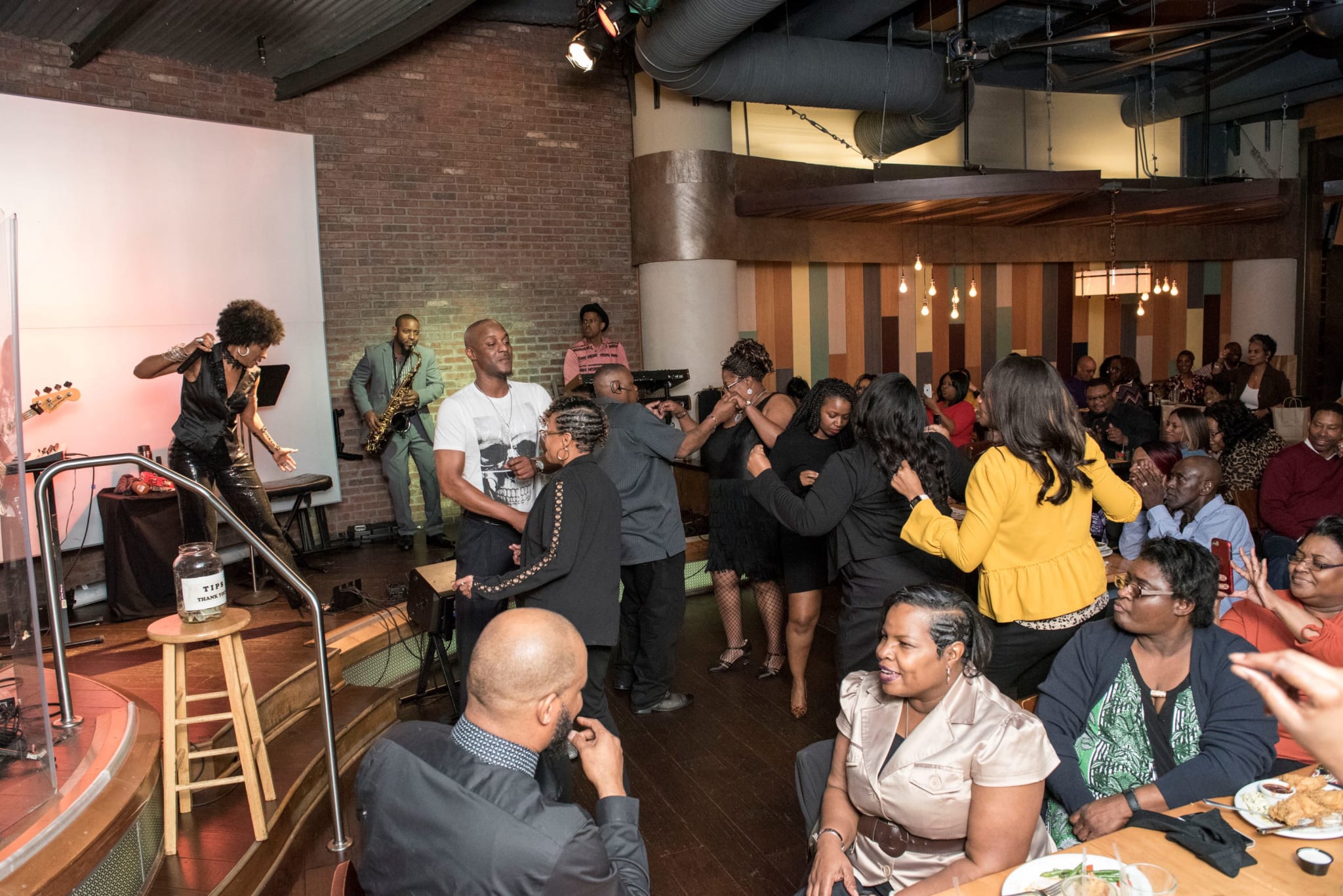 A lively indoor party with a band performing on stage and guests dancing and socializing in Atlanta, Georgia.