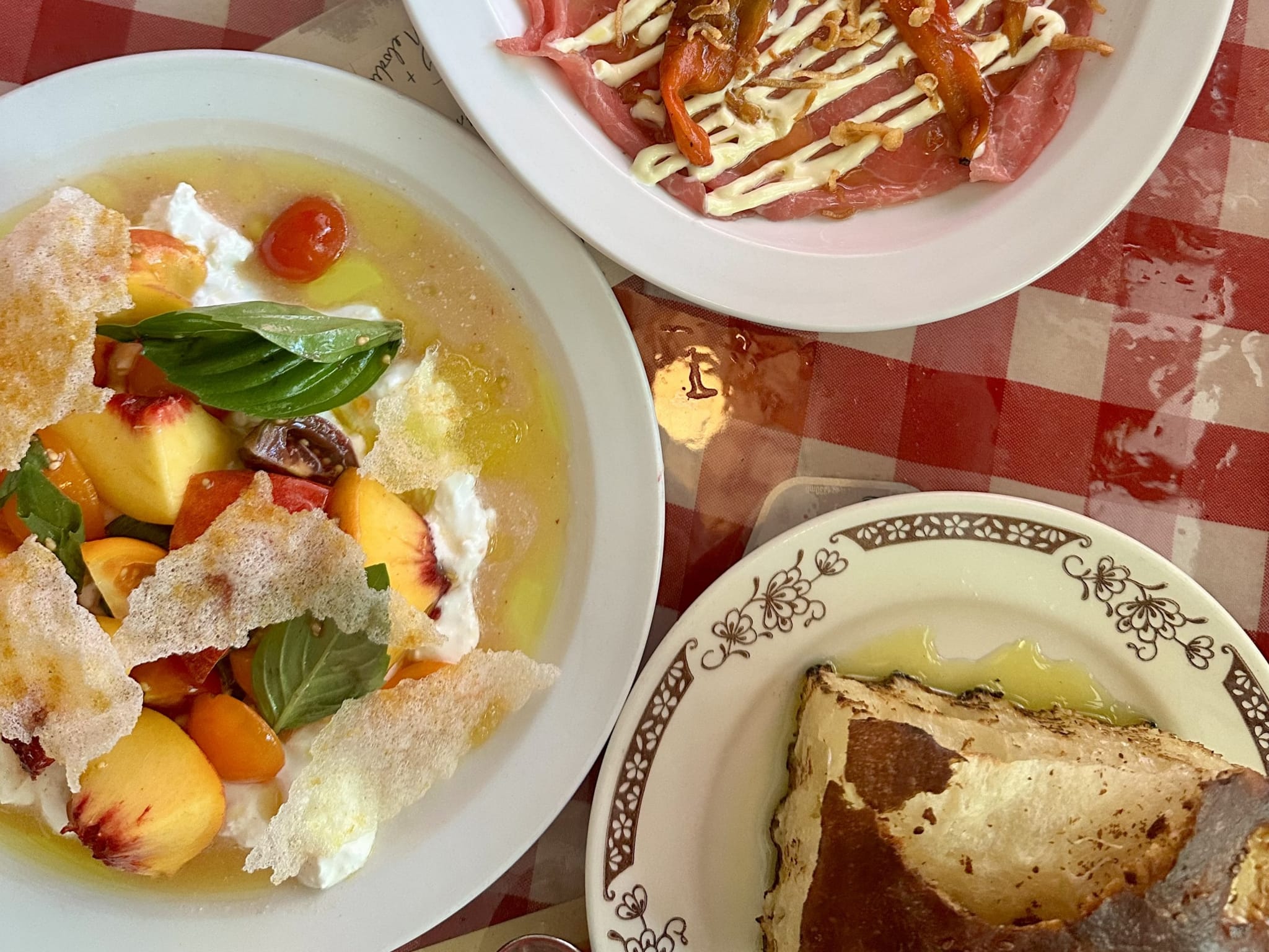 Three plates of food on a red and white checkered tablecloth in Atlanta, Georgia.