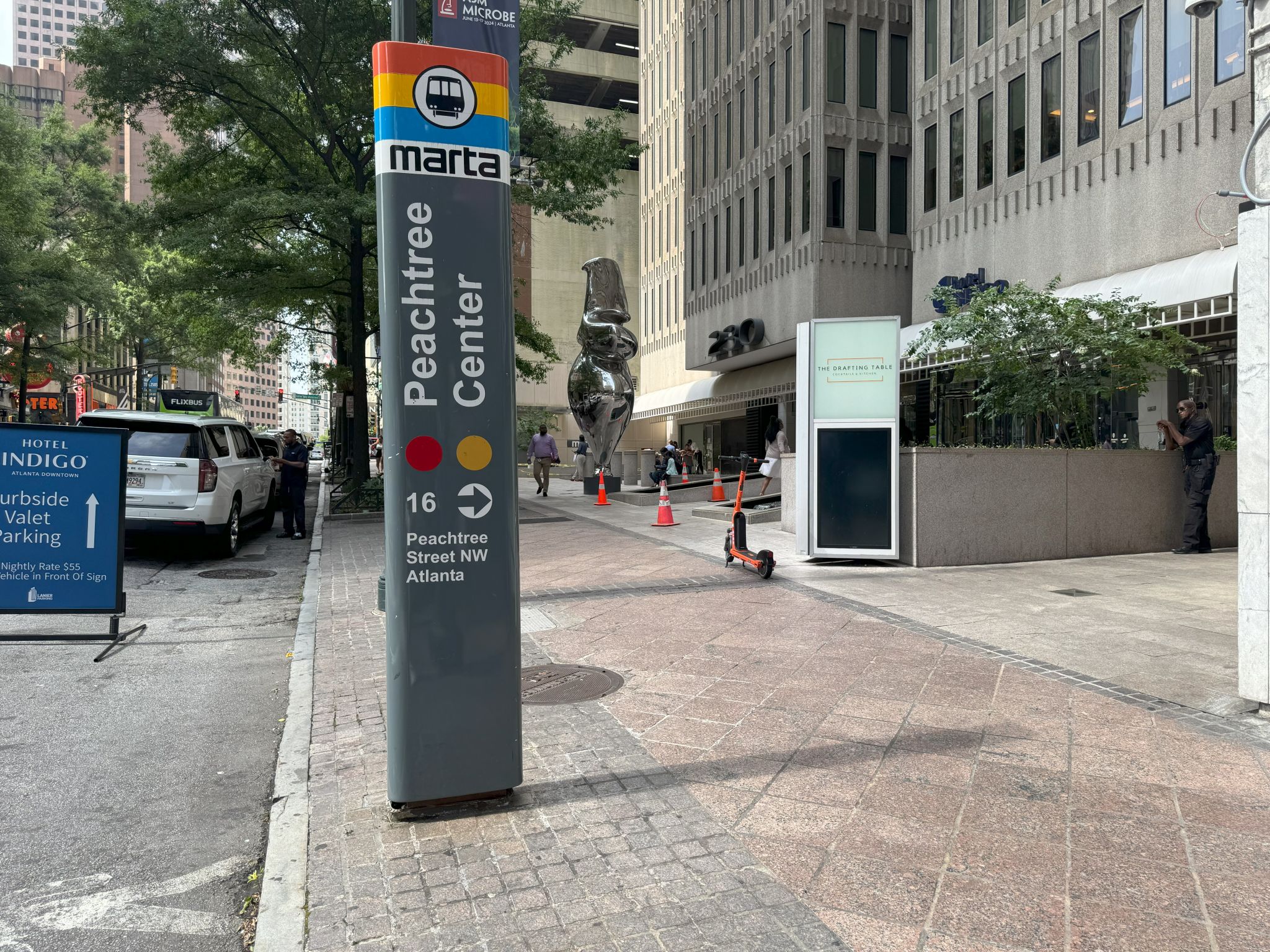A city street scene with a MARTA sign, pedestrians, and urban architecture in Atlanta, Georgia.