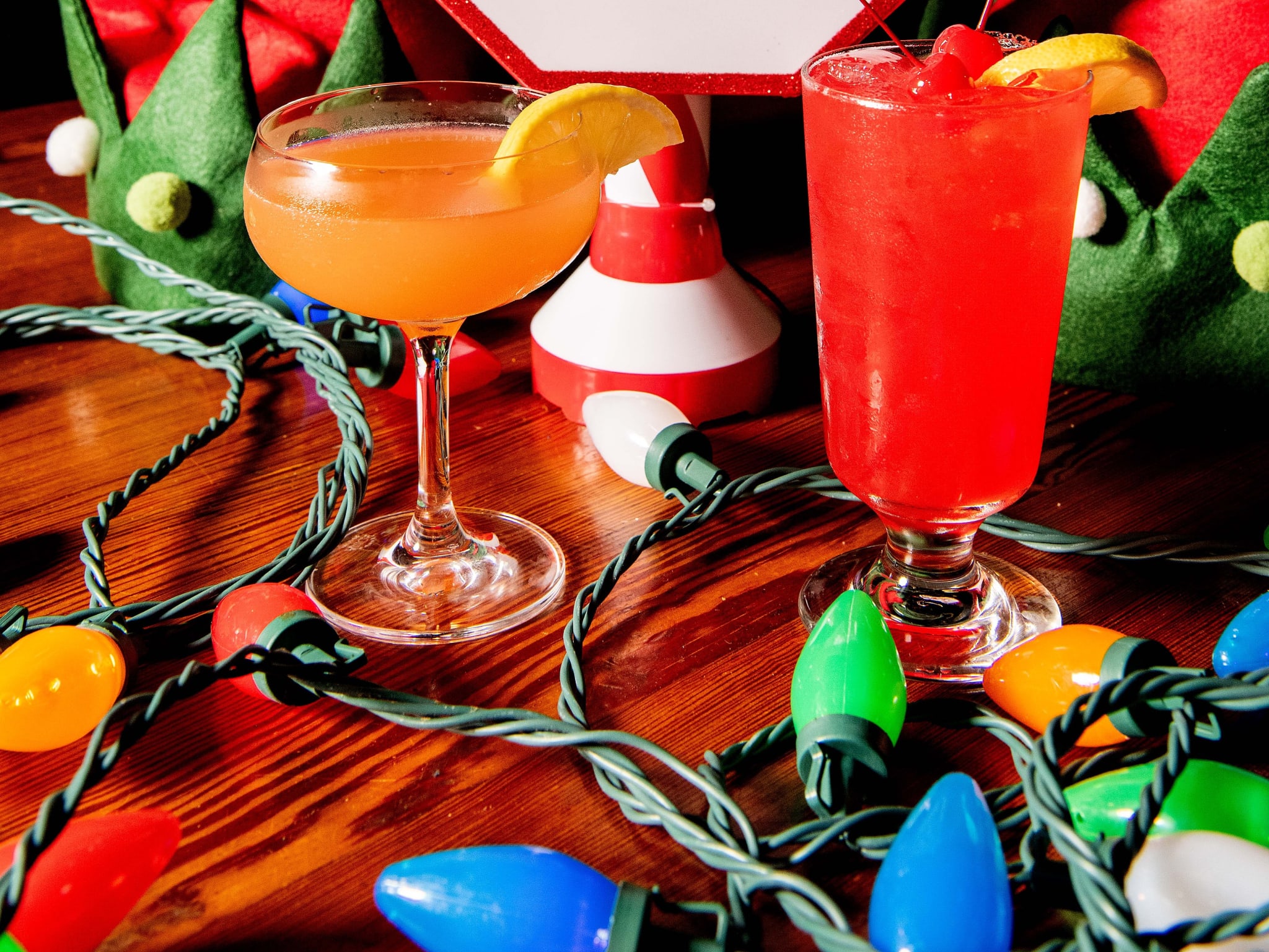 A festive holiday scene with Christmas lights, Santa hat, and two colorful cocktails in Atlanta, Georgia.