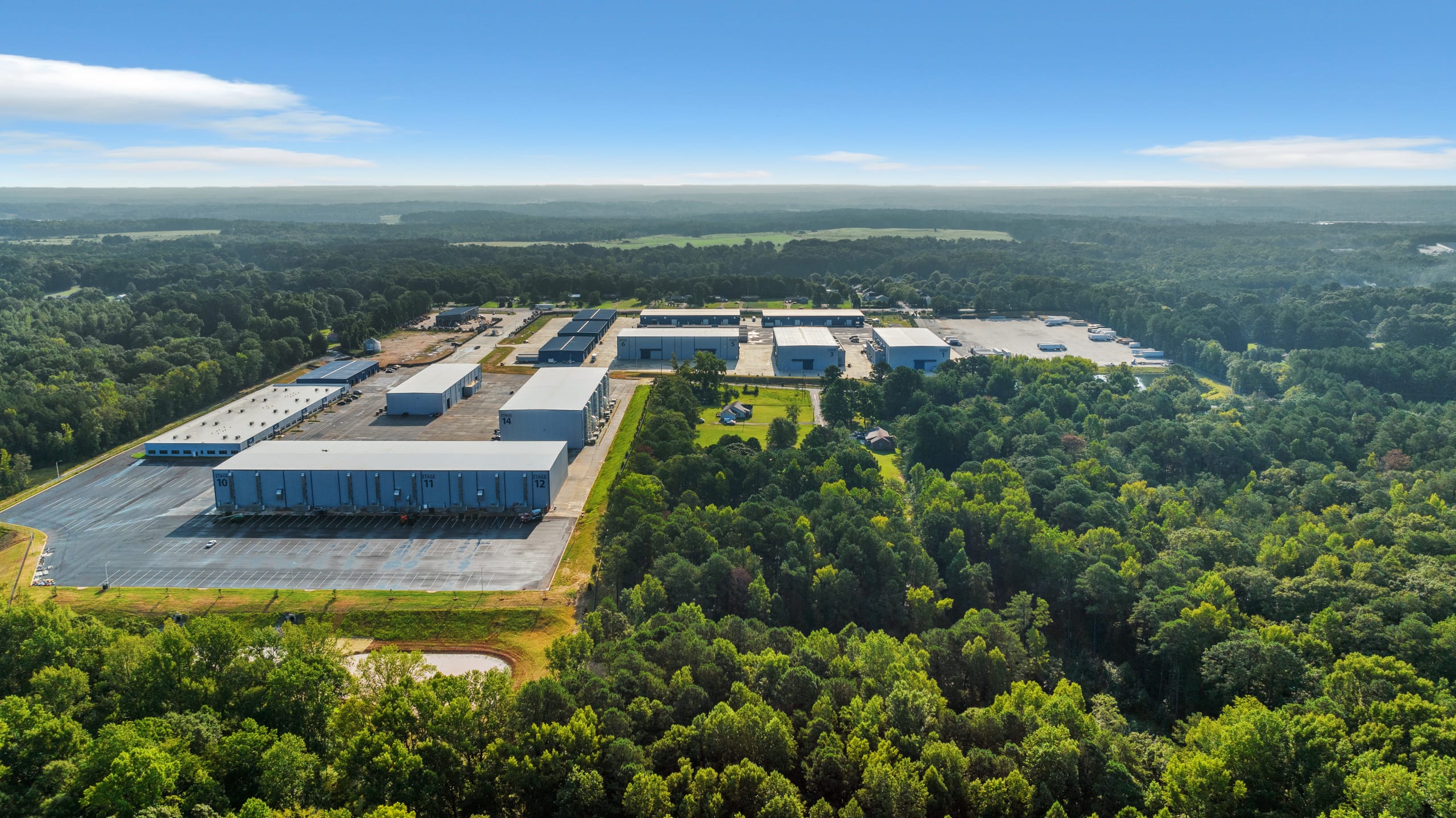 Film Studios in and around Atlanta 6 Aerial view of industrial complex with multiple large buildings surrounded by lush green forest in Atlanta, Georgia.