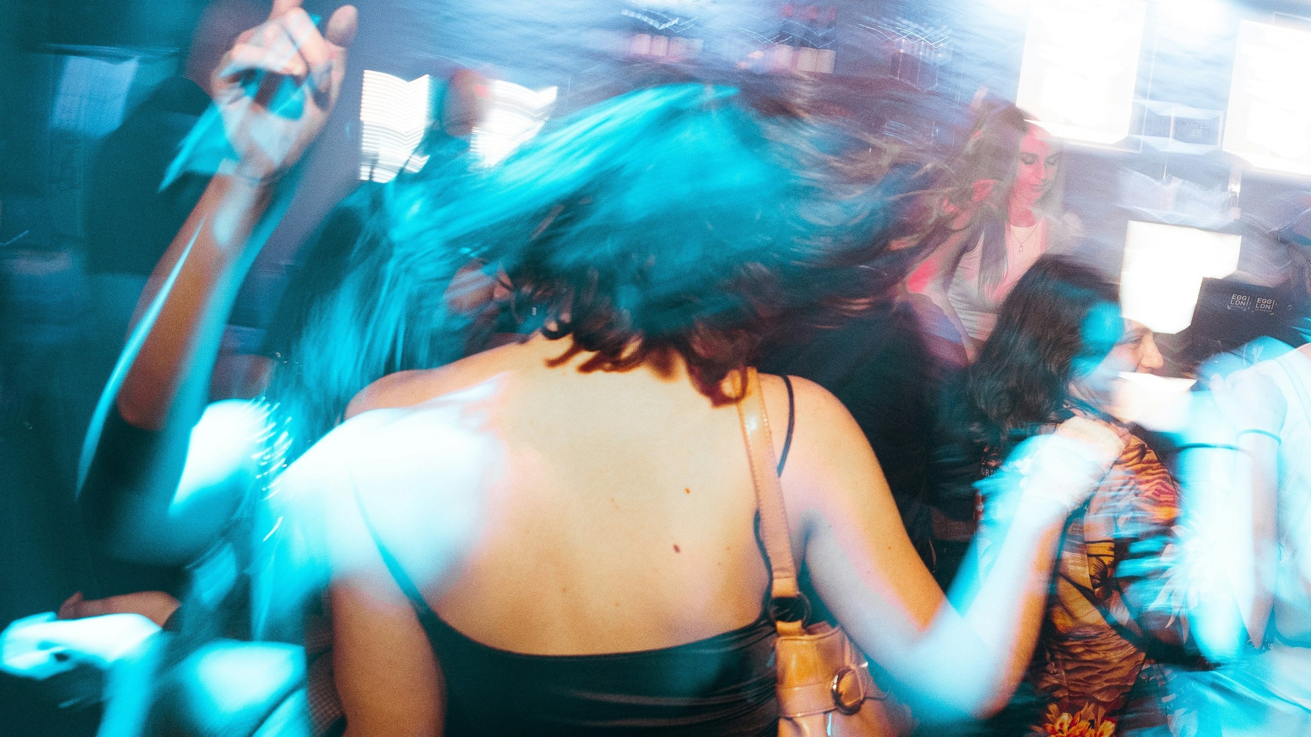 A blurred image of people dancing in a dimly lit room with blue lighting in Atlanta, Georgia.