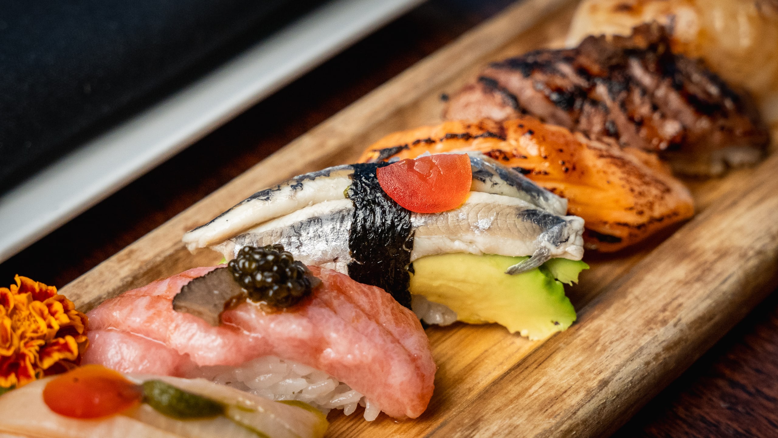 Assorted sushi pieces with various toppings on a wooden platter in Atlanta, Georgia.