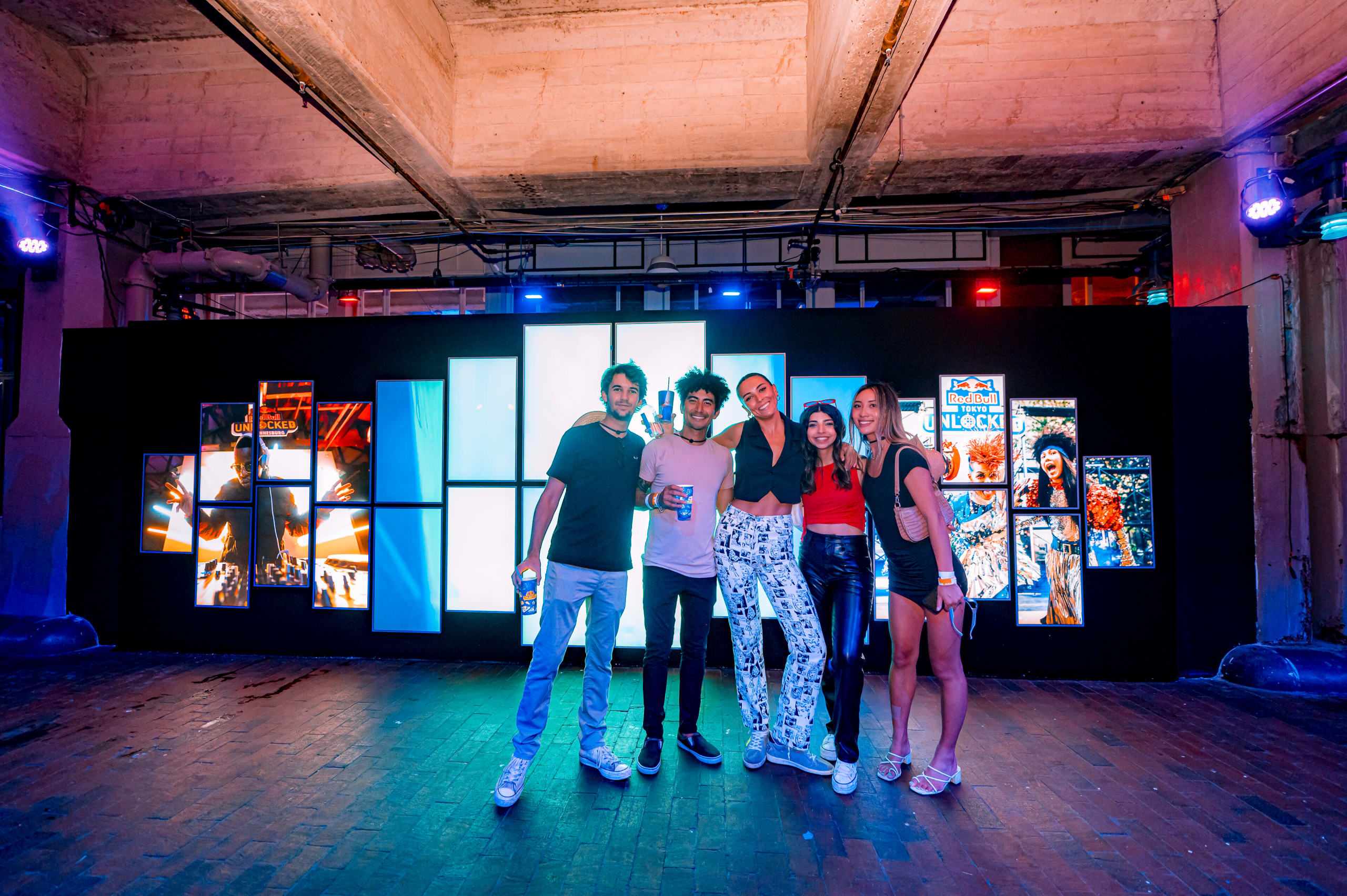Underground Atlanta 1 Five friends pose together in a brightly lit warehouse with colorful art displays in Atlanta, Georgia.