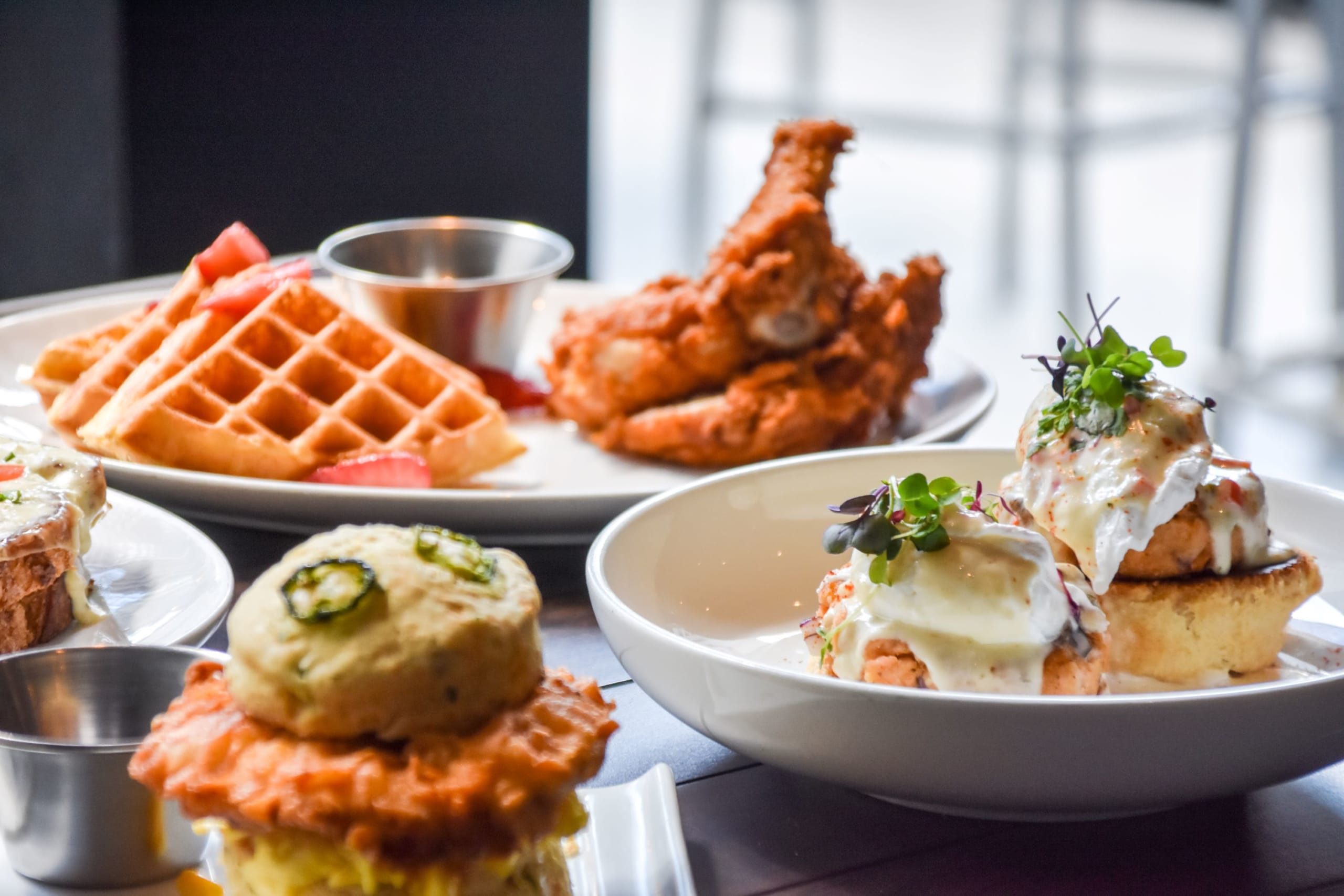 @DiscoverAtlanta Link In Bio 113 A variety of fried foods including chicken, waffles, and sandwiches with creamy toppings in Atlanta, Georgia.