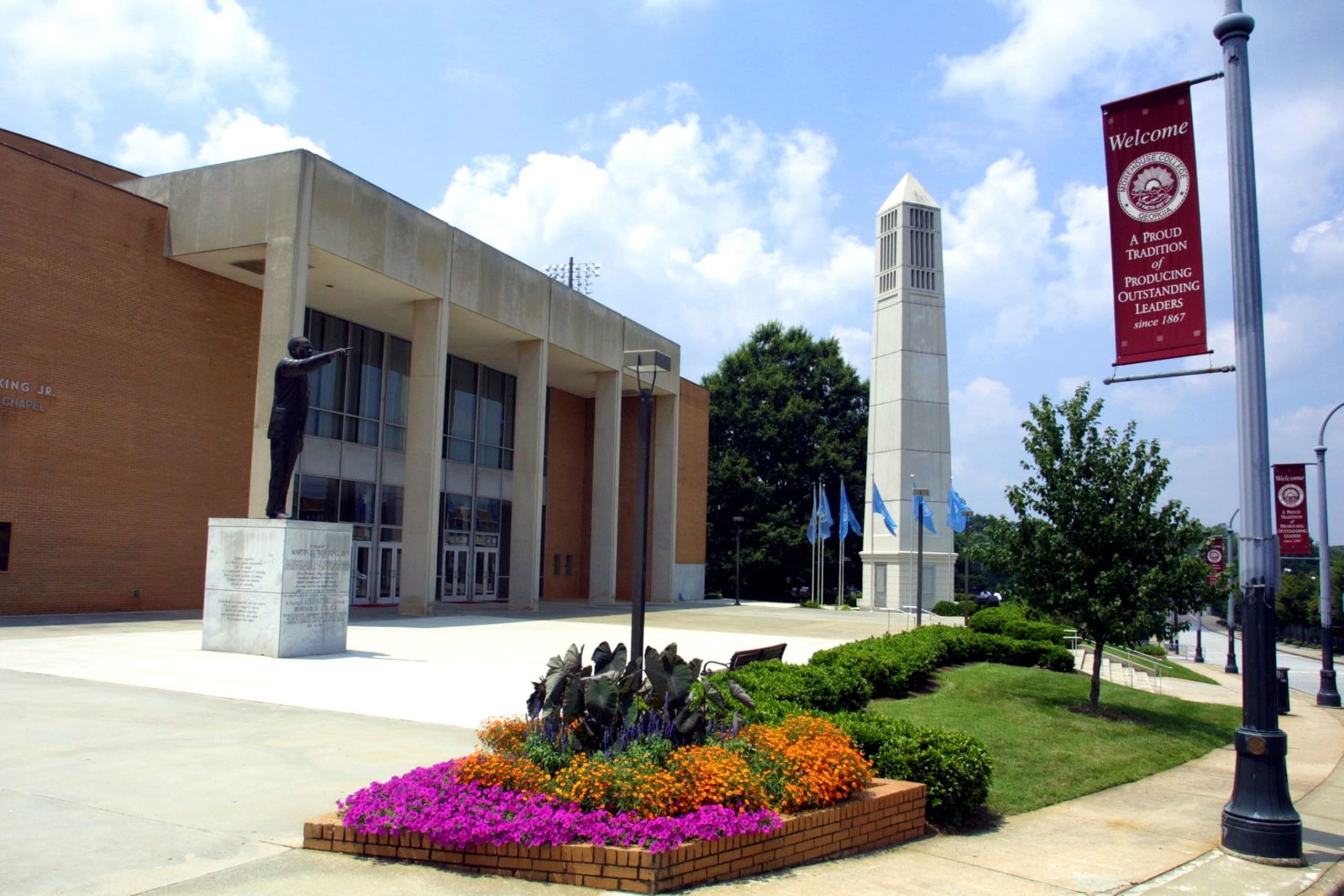 Modern building with statue, bell tower, and colorful flower beds in front in Atlanta, Georgia.