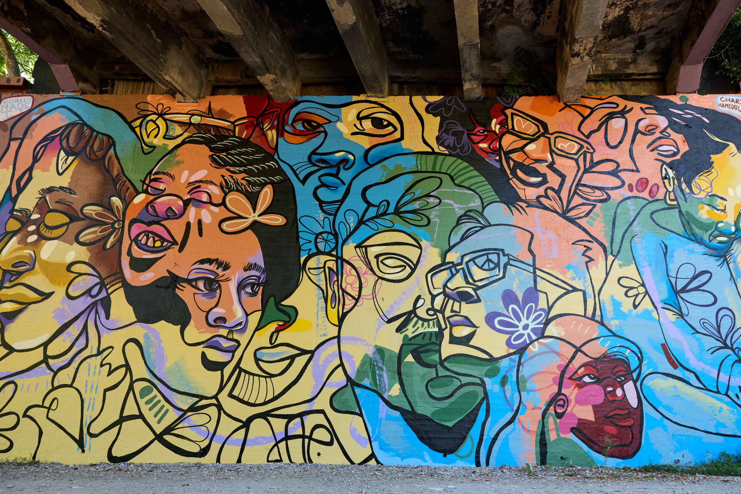A vibrant mural featuring abstract faces and floral patterns in bright colors in Atlanta, Georgia.