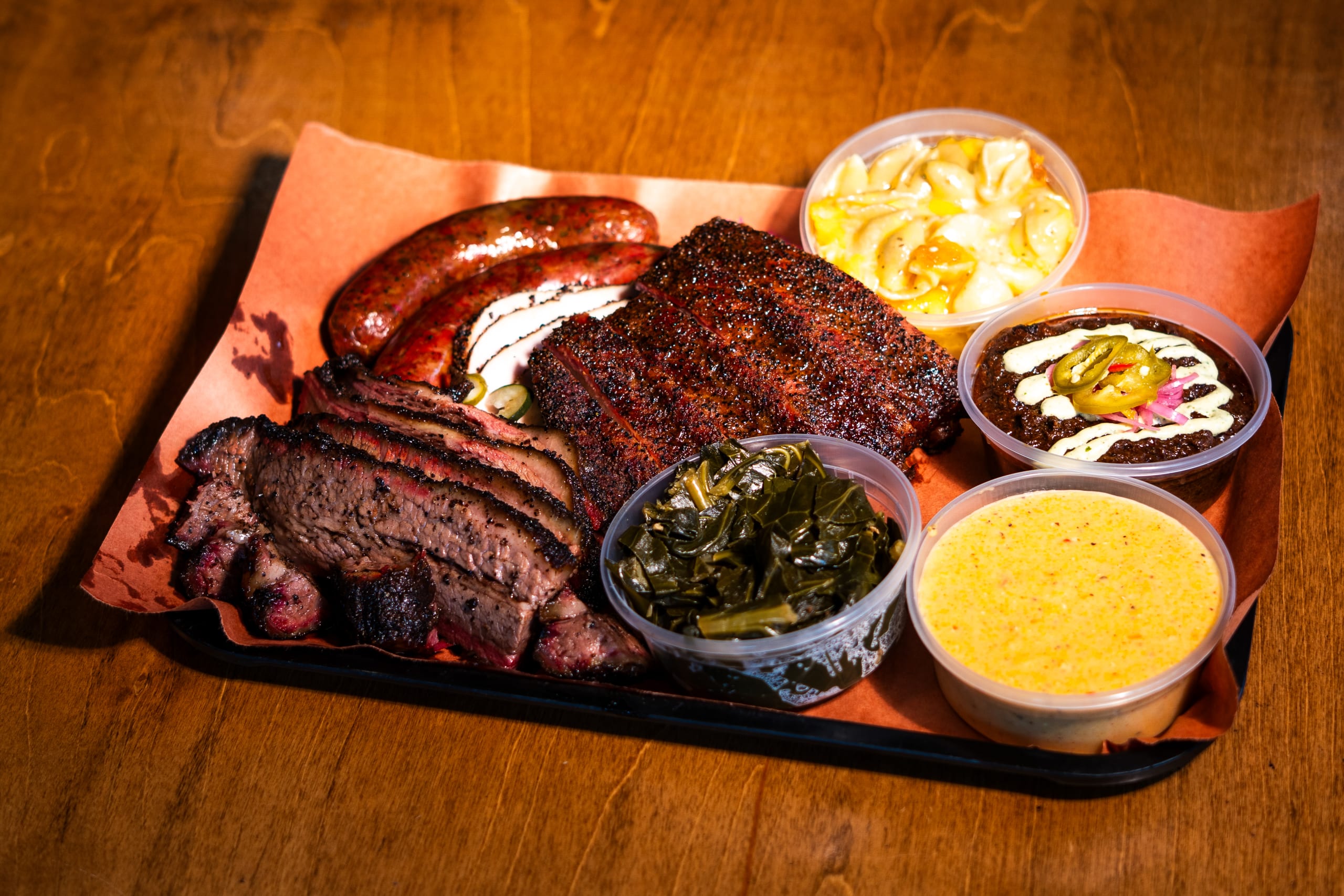MLB ALL-STAR RESTAURANT WEEK 37 A mouthwatering barbecue platter featuring smoked meats, macaroni and cheese, and collard greens in Atlanta, Georgia.