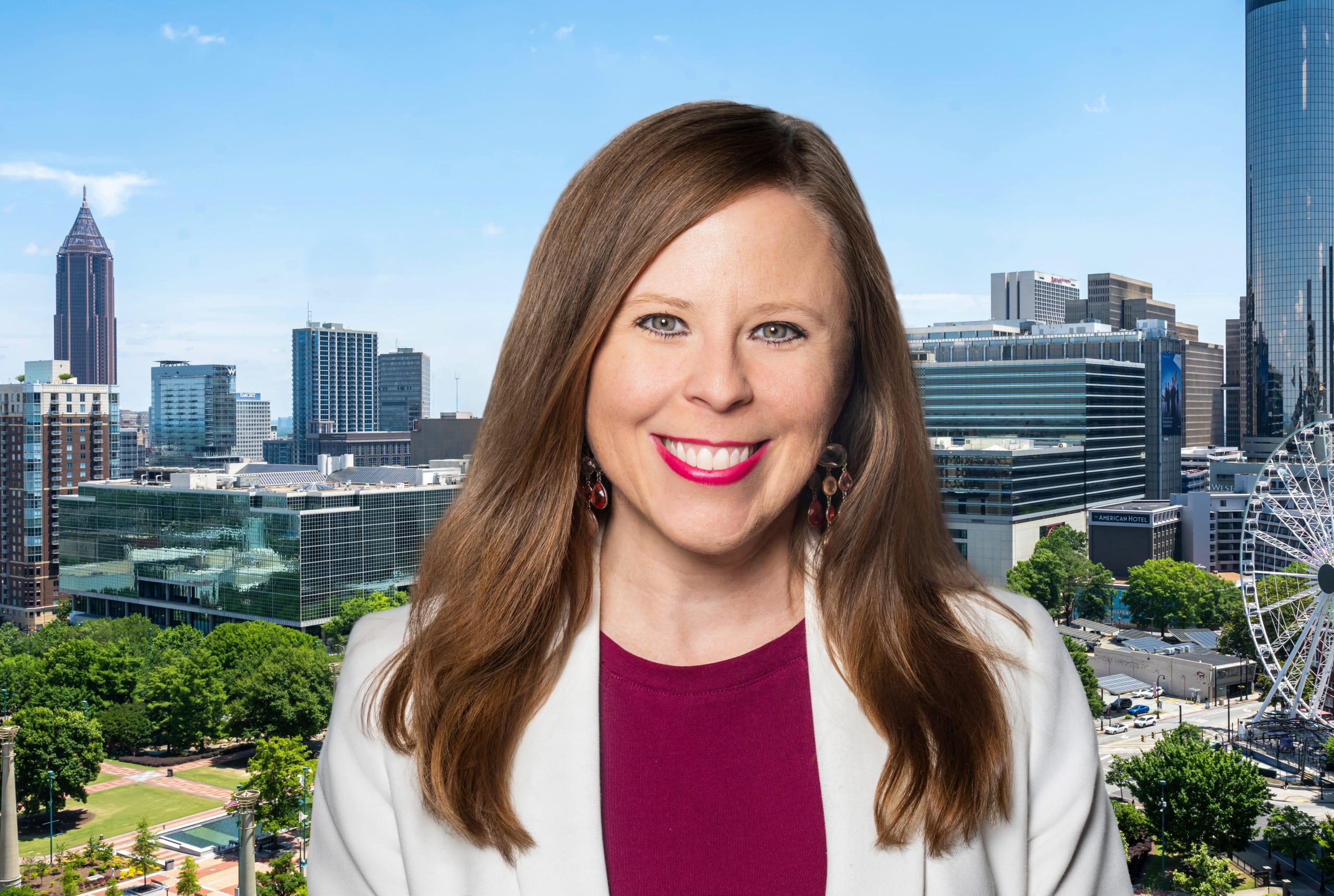A smiling woman in a white blazer stands against a backdrop of a city skyline with skyscrapers and a Ferris wheel in Atlanta, Georgia.