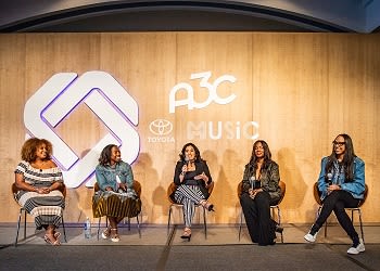 A3C Festival & Conference 4 Five women sit on stage at an event with a large logo and 'Music' text behind them in Atlanta, Georgia.