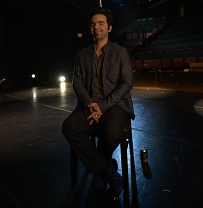Michael Haverty 1 A man sits on a chair in an empty theater, smiling at the camera in Atlanta, Georgia.