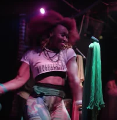 Speech, Arrested Development 2 A woman with an afro hairstyle is dancing energetically on stage, wearing colorful clothing and jewelry in Atlanta, Georgia.