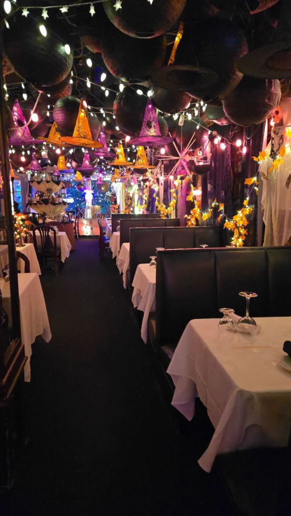 Grown-Up Guide to Halloween in Atlanta 1 A dimly lit restaurant decorated with colorful hanging lights and Halloween-themed ornaments in Atlanta, Georgia.