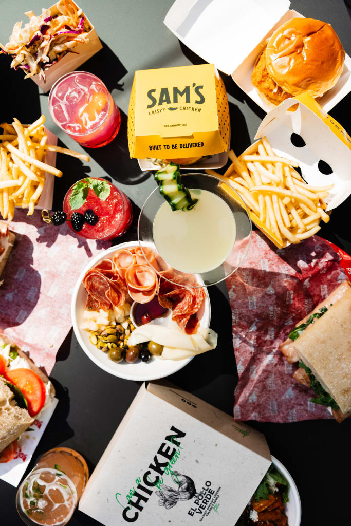 Assorted fast food items including burgers, fries, salads, and drinks laid out on a table in Atlanta, Georgia.
